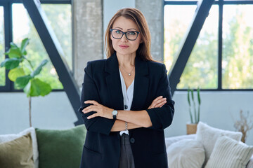 Portrait of middle-aged confident business woman looking at camera