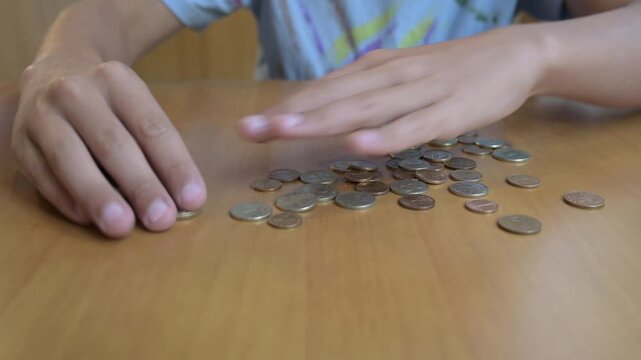 Hands counting Bulgarian lev coins on a wooden table. Concept of finance, savings, economy, money management, currency, budgeting, and daily expenses in Bulgaria