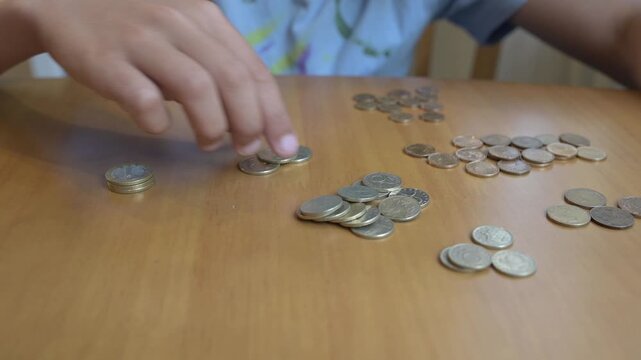 Hands counting Bulgarian lev coins on a wooden table. Concept of finance, savings, economy, money management, currency, budgeting, and daily expenses in Bulgaria
