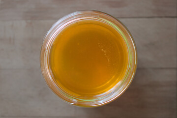 Honey in glass jar on wooden background