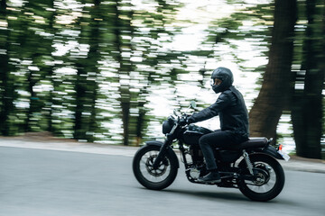Fototapeta premium Driving fast. Man in leather clothes on motorcycle is on the road