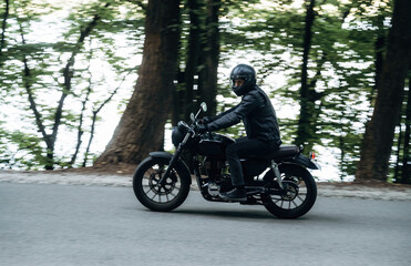 Driving fast. Man in leather clothes on motorcycle is on the road
