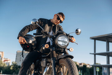 Bright sunlight, parked. Man is outdoors with his motorcycle