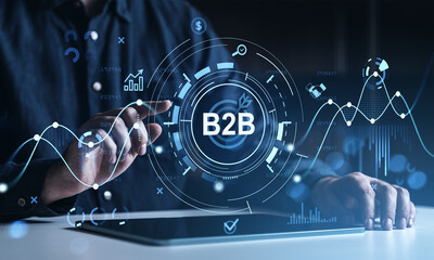 Businessman using tablet with B2B interface and digital data graphics overlay.
