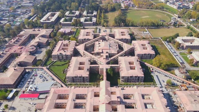 Aerial view of Ayub Medical College with its complex of buildings, roads, parking and green spaces contrasting with the surrounding urban area, Abbottabad, Khyber Pakhtunkhwa, Pakistan.