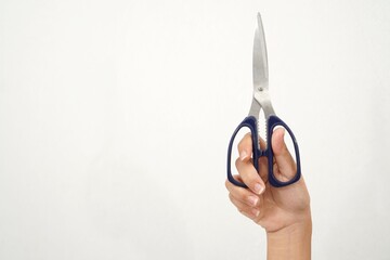 Female hands holding black scissors Isolated on white background. Closeup.