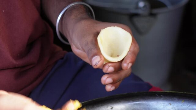 The person is preparing samosa by his hands