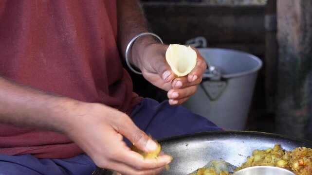 A person preparing samosas, a popular South Asian street food snack