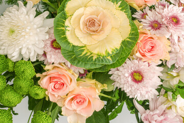 Bouquet of flowers with pink roses, brassica flower, chrysanthemum and freesia flower in a vase.