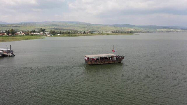 A ship sailing off the coast of Ginosar in the Sea of ​​Galilee, Tiberias, from the drone view, Israel