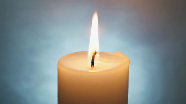 Single beige candle burning quietly with gentle flame and calm background, evoking peaceful and spiritual mood.