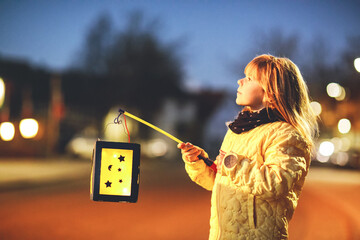 Little preschool kid girl holding selfmade traditional lanterns with candle for St. Martin procession. child happy about children and family parade in kindergarten. German tradition Martinsumzug © Irina Schmidt