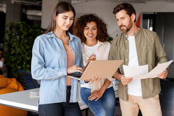 Business team working together on laptop in modern office