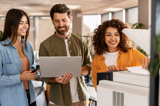 Business team printing documents in office using photocopier machine
