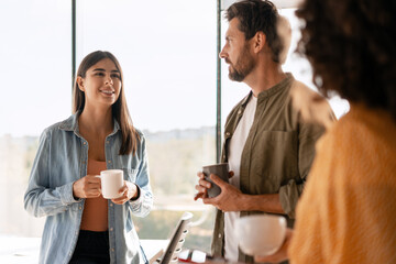 Creative business team enjoying coffee break during meeting in modern office