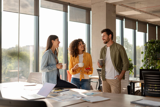 Coworkers chatting and drinking coffee during office break