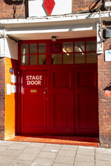 A close view of a red stage door back entrance