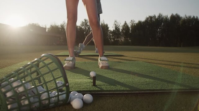 Woman in sports shoes adjusts ball before hitting against man