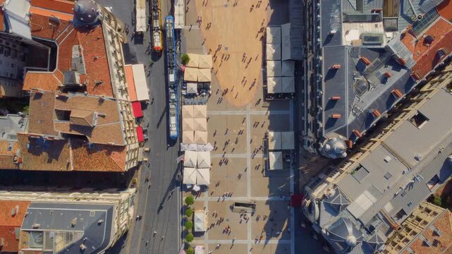 A drone footage shows the vibrant heart of Montpellier, France, showcasing a bustling city square surrounded by historic architecture and lively pedestrian activity.