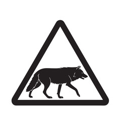 Triangular warning sign with a silhouette of a wolf walking, indicating potential wildlife presence on the road, a cautionary symbol for drivers