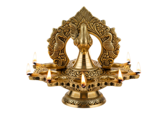 Ornate, golden oil lamp with intricate peacock designs and burning flames, presented against a stark black backdrop.