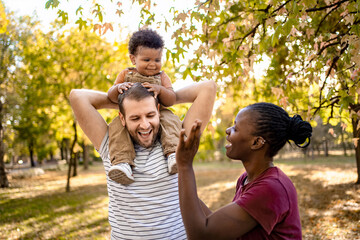 Joyful family moment in a sunlit park during autumn