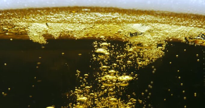 Slow Motion Abstract Macro Of Dark Golden Liquid With Foam And Rising Bubbles, Carbonated Texture Background For Drinks, Refreshment, Celebration And Creative Beverage Concept At 1000 Fps