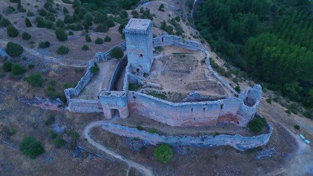 Aerial view from a drone of the sunset at the castle in the town of Ucero, in the Burgo de Osma region, Soria Province, Autonomous Community of Castile and Leon, Spain. Europe