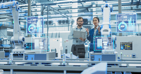 Electronics Factory Assembly Line Digitalization: Automated Robot Arms Manufacturing Advanced Equipment. Managers Discussing Work while Futuristic AI Computer Vision Analyzing, Scanning Conveyor Line