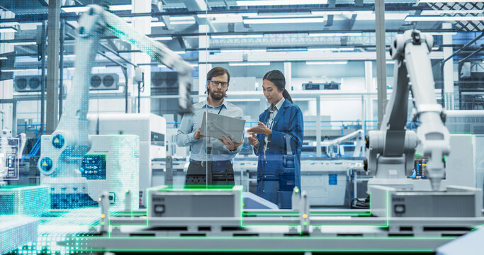 Electronics Factory Assembly Line Digitalization: Automated Robot Arms Manufacturing Advanced Equipment. Managers Discussing Work while Futuristic AI Computer Vision Analyzing, Scanning Conveyor Line
