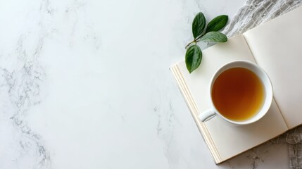 Cup of tea and notebook on marble background, ideal for calm atmosphere, social media post, or mindful living concept