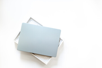 Silver laptop in a box on white desk top. Unpacking new gadget, top view