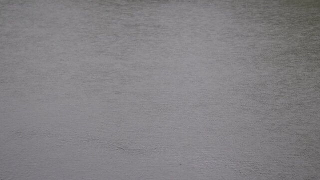 The surface of water of a river or lake, with ripples from wind or rain