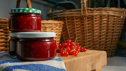 Rustic arrangement of homemade red currant jam jars by some fresh currant berries. Homemade preserves and natural ingredients with by traditional recipes. 