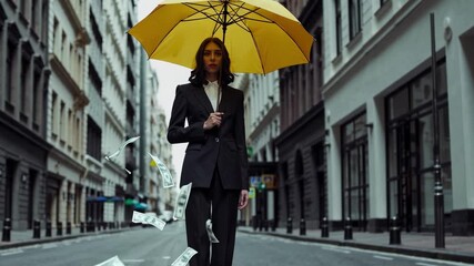 White businesswoman in a formal suit standing under a yellow umbrella while banknotes rain down around her. Conceptual illustration of wealth, financial protection, and success - Powered by Adobe