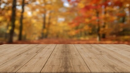 Empty rustic wooden table surface with a vibrant blurred autumn forest in the background, perfect for seasonal product displays or creative text overlays