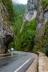 beautiful road and dramatic landscape in mountain gorge and forest against a cloudy sky