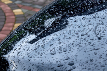 Black car Hood with Hydrophobic Coating. Glistening Raindrops on Car