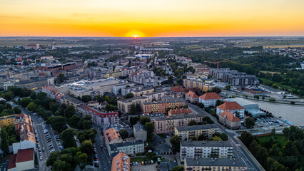 Sunset panorama of Kalisz, view of residential districts, streets and trees, wide perspective of the city surrounded by greenery in golden evening light.