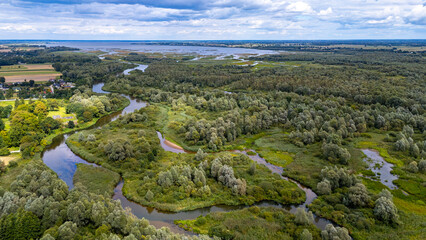 Aerial drone view of Warta River bends in Jeziorsko nature reserve, dense riparian forests, green...