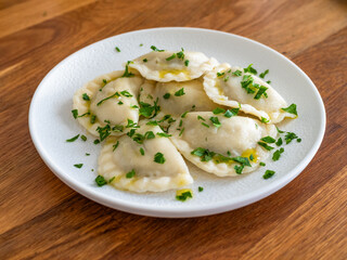 Dumplings - polish pierogies with parsley on wooden table