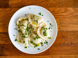 Dumplings - polish pierogies with parsley on wooden table