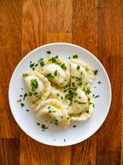 Dumplings - polish pierogies with parsley on wooden table