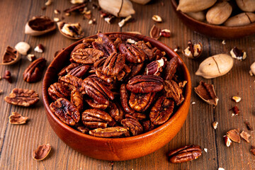 Pecans, peeled and shelled, whole and crushed into pieces. Candied caramelized and raw fresh pecans, autumn harvest, delicious snack, ingredient for baking, pies, cookies