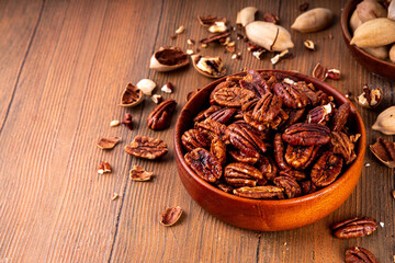 Pecans, peeled and shelled, whole and crushed into pieces. Candied caramelized and raw fresh pecans, autumn harvest, delicious snack, ingredient for baking, pies, cookies