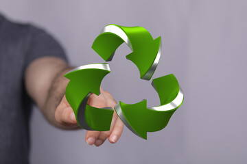 Eco-friendly concept.  Man's hand presents a 3D recycle symbol. Sustainable future.