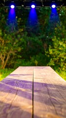 Wooden table in a park at night with spotlights