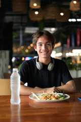Young Thai Asian man eating traditional food in Thailand Pad Thai