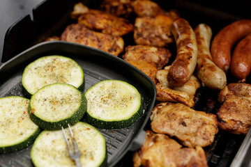 Summer BBQ feast! Grilled chicken, sausages, and zucchini.