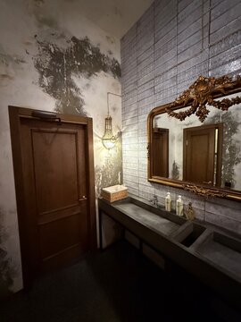 Vintage industrial bathroom interior with ornate mirror